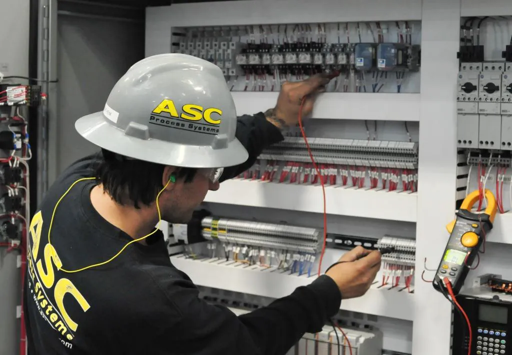 An ASC electrician testing wiring in a CPC control panel