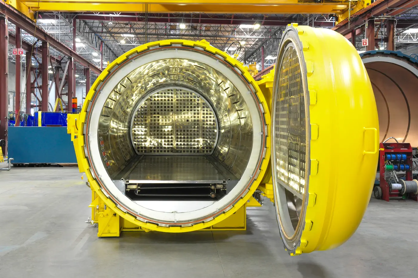 An ASC Econoclave on the shop floor with its door swung open, showing the H-Slot panels inside