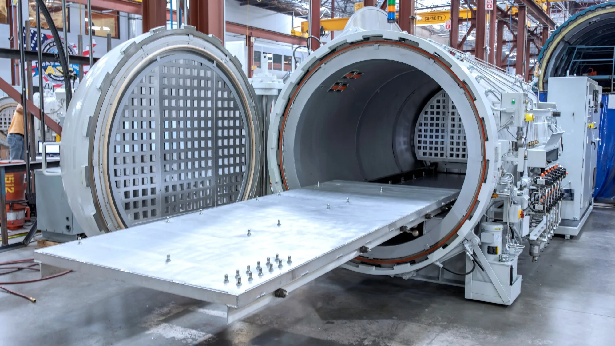 An open white Econoclave with its loading table extended and the H-Slot airflow panels visible inside