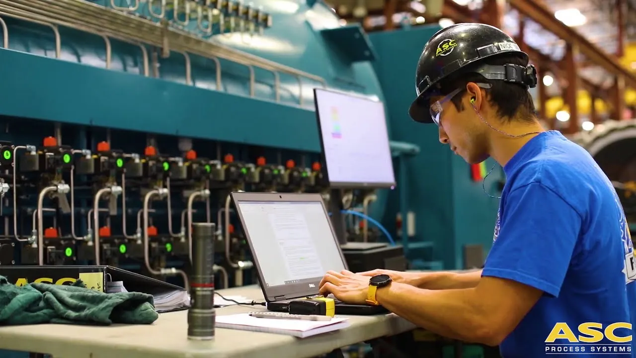 An ASC engineer testing a control system beside an autoclave